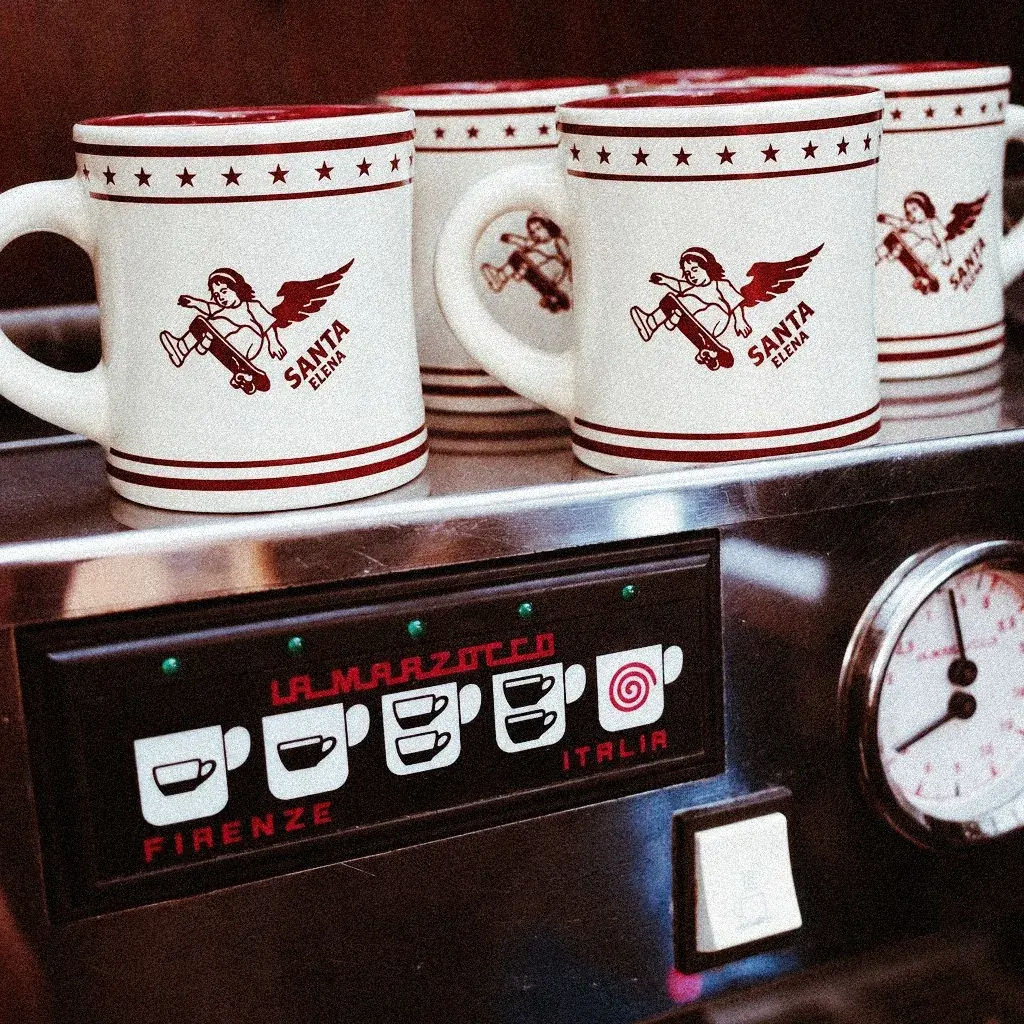 Tazas de Santa Elena apiladas sobre la máquina de espresso La Marzocco