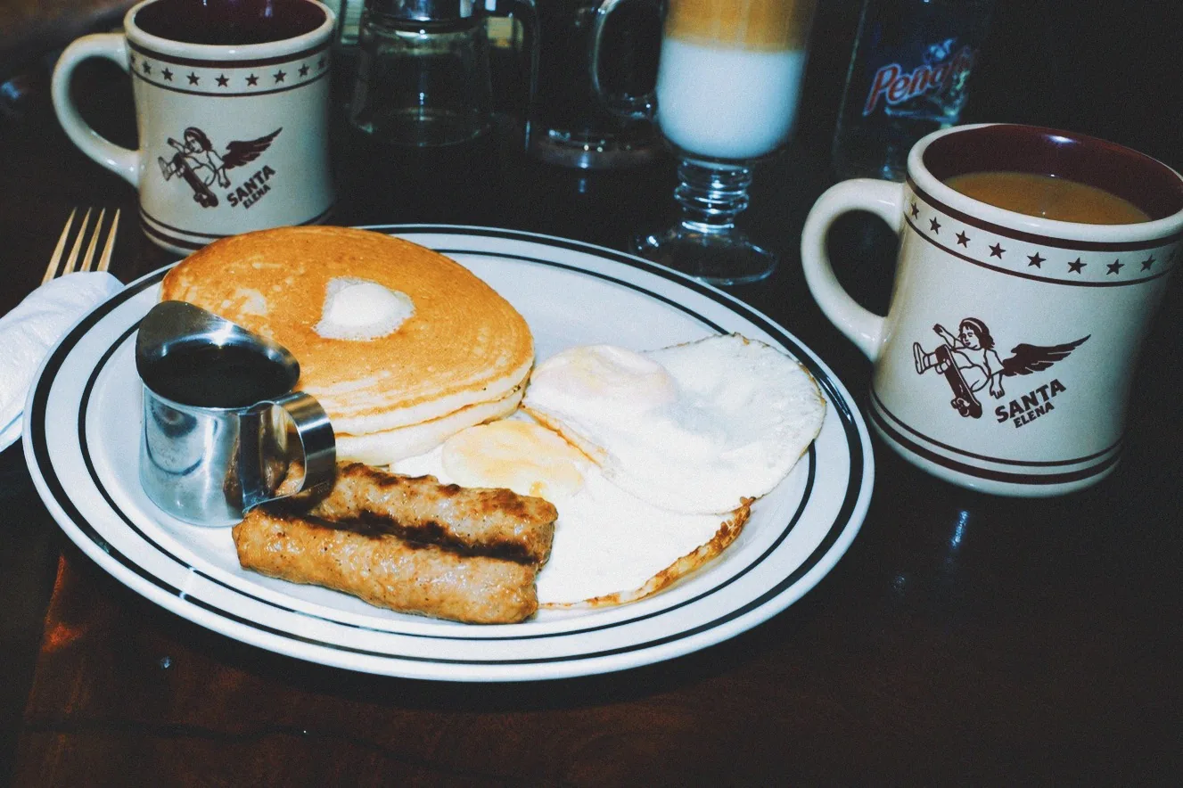 Dos tazas de Santa Elena acompanando un desayuno de hotcakes y huevos