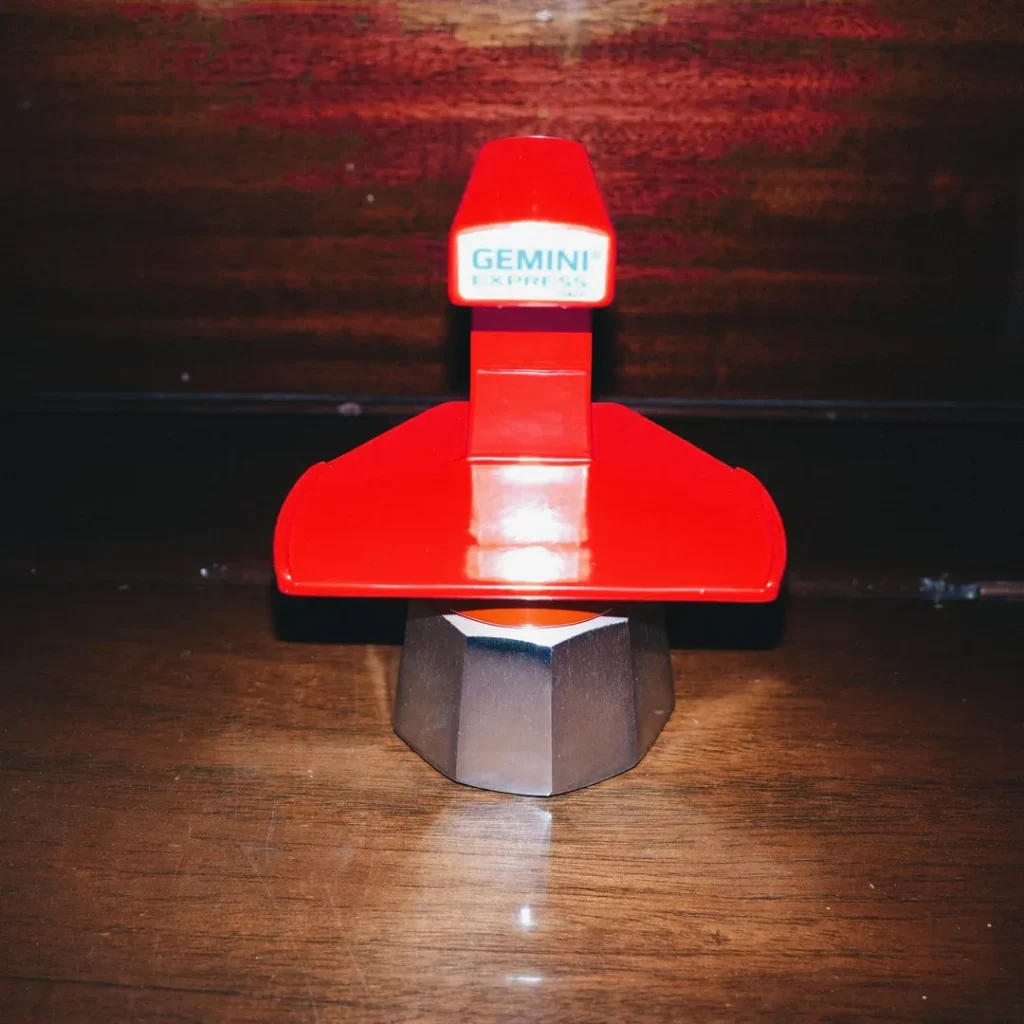 Cafetera Gemini Express roja sobre una mesa de madera oscura