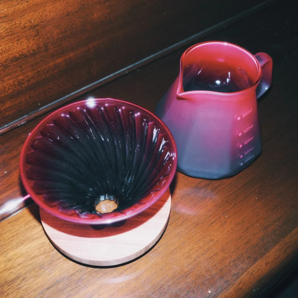 Cono del dripper tornasol y la jarra por separado sobre una mesa de madera