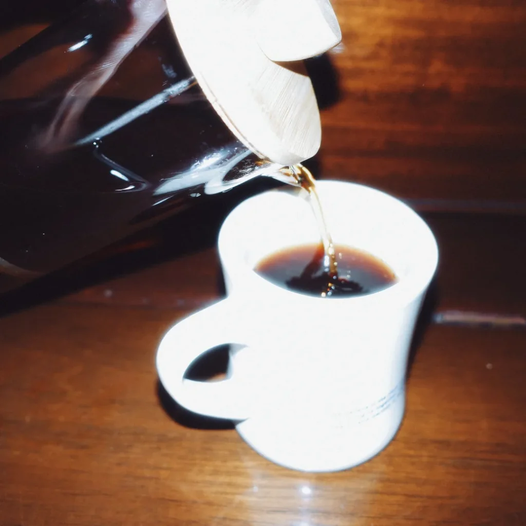 Sirviendo café de la prensa francesa en una taza blanca