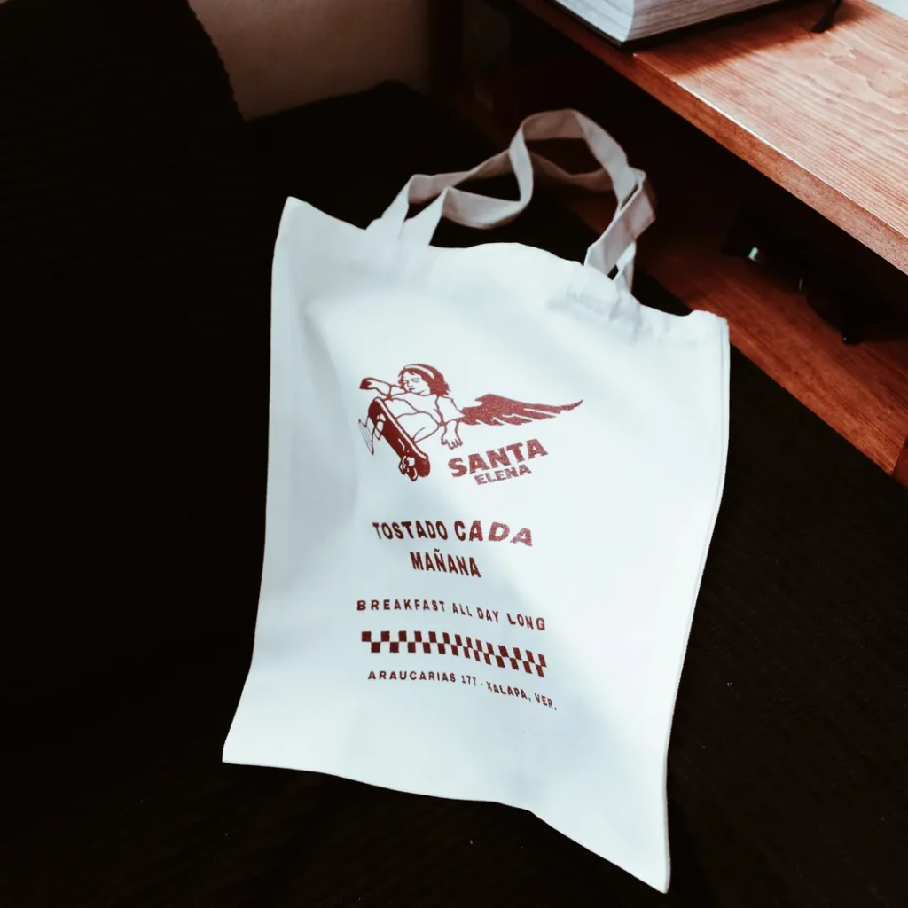 Tote bag blanca de Santa Elena sobre una mesa de madera